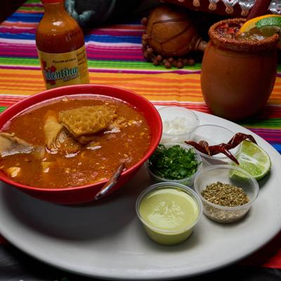 Mexican tripe soup served with chopped onions, cilantro, oregano, and Cantarito cocktail.