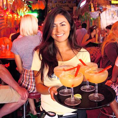 A staff member holding a tray with cocktails