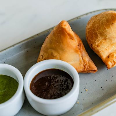 Samosas, with dipping sauces.