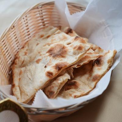 Naan bread served in a basket lined with paper.