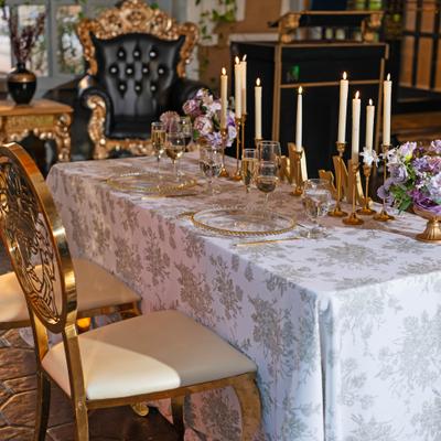 Sweethart table covered in a white damask tablecloth with lit candles and floral arrangements.