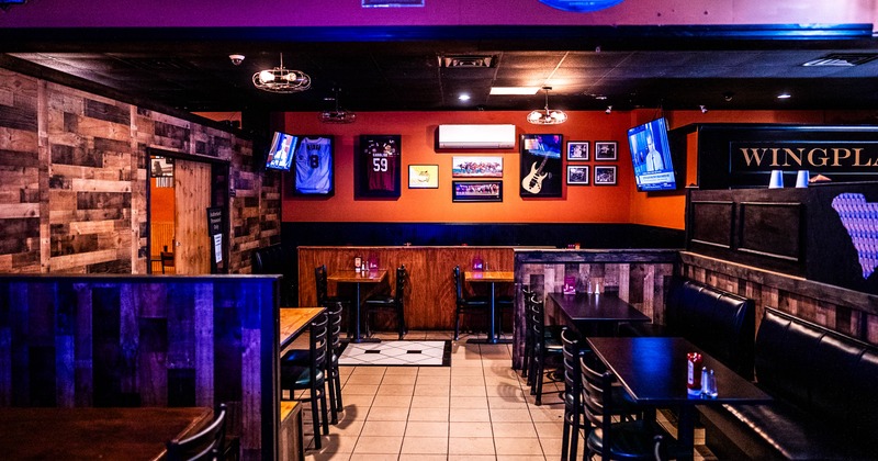 Interior of a restaurant with wooden paneling, sports memorabilia, and arranged tables