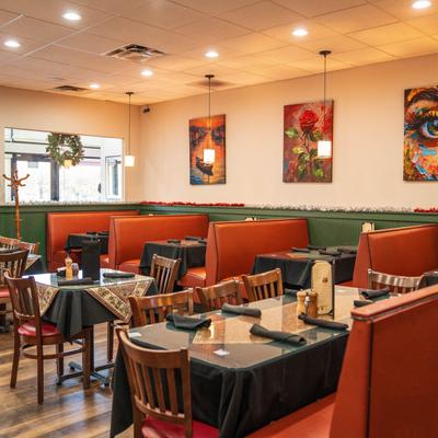 Restaurant interior, dining area, tables for four, seating booths in the back.