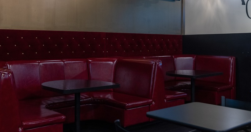 Interior seating area with upholstered red leather booths