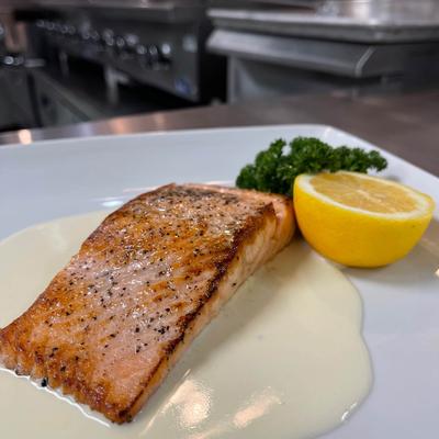 Grilled salmon filet in sauce, with lemon and parsley