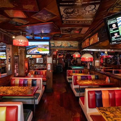 Cozy, dim-lit diner with colorful striped booths and wooden decor