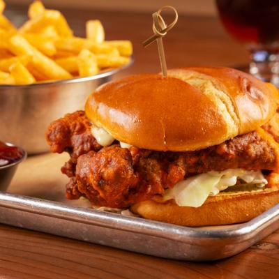 Buffalo fried chicken sando with fries and ketchup.