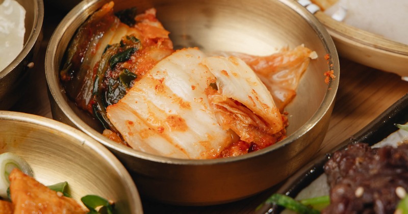 Kimchi served in a brass tableware on a Bulgogi platter