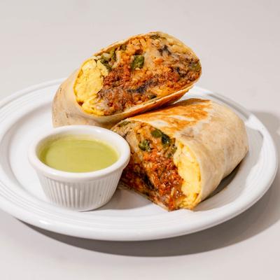 Breakfast Burrito next to a small cup of green sauce.