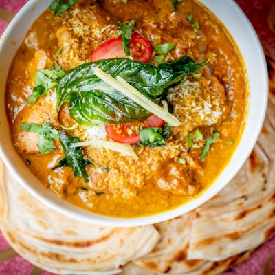 Creamy chicken curry topped with basil, charry tomatoes, and ginger.