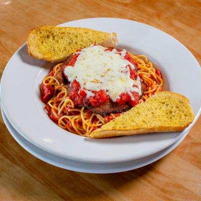 Chicken Parmesan served over spaghetti with toast on the side.