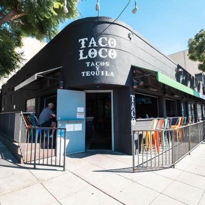 Taco Loco restaurant exterior with colorful bar stools and open windows.