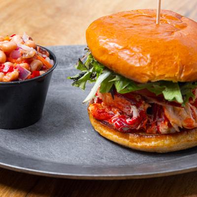 Lobster on a roll served with a bean salad on the side.