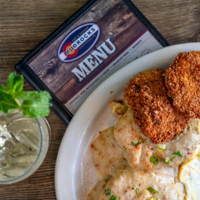 Fried Chicken, Biscuits and Gravy Platter served alongside a drink and a menu.