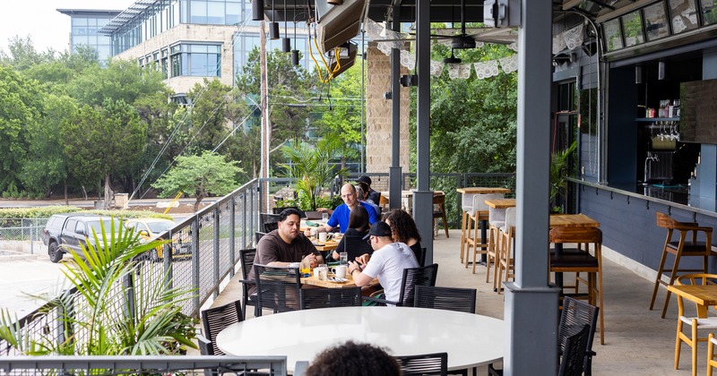 Exterior, round table, chairs, guests, bar tables and stools