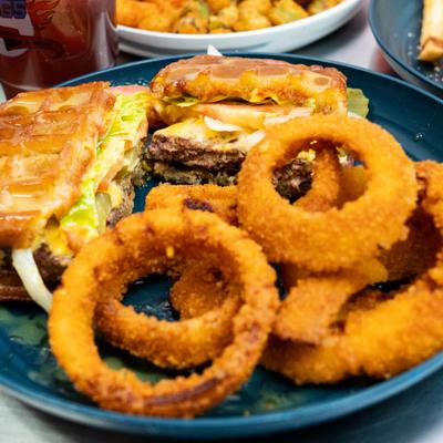 Famous Mike’s Waffle Burger served with onion rings.