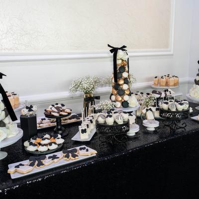 Dessert table arranged with black and white treats.