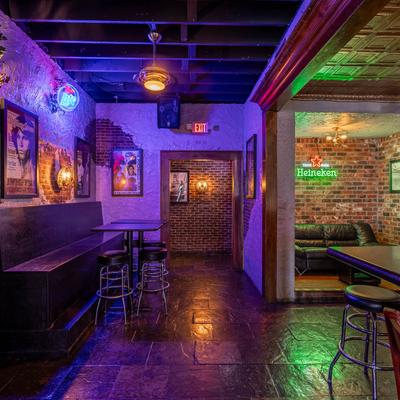 Interior space with seating and colored lighting around the room.