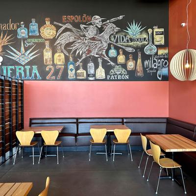 Dining area, banquette tables and seats with mural art.