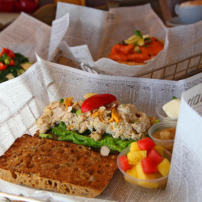 Sandwich with green salad, white topping and tomato, closeup