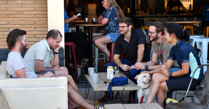 A group of people sitting at a table outside, enjoying their time