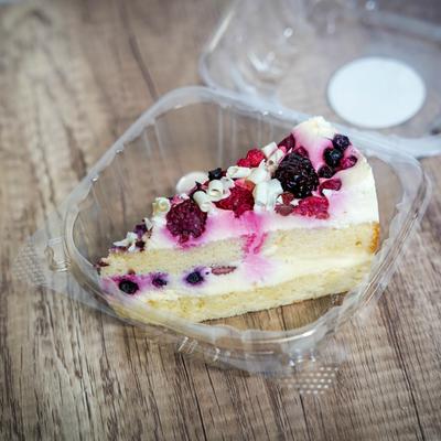 A slice of berry layer cake in a to-go container.