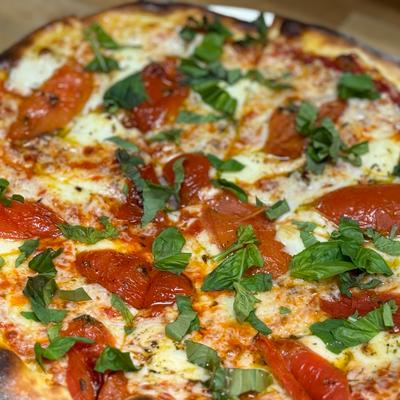 Margherita pizza, house-made red sauce, fresh tomato,  basil, fresh mozzarella.