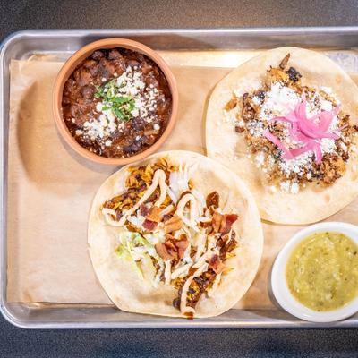 Pork belly and chicken tacos, served with drunken black beans and salsa.