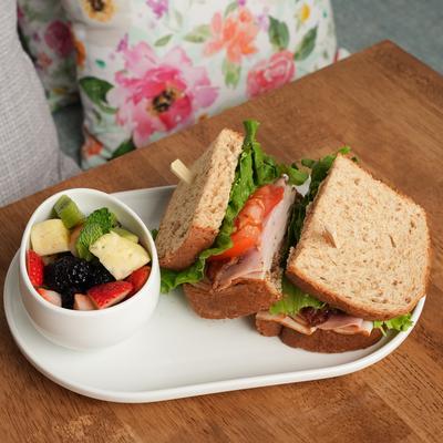 The club sandwich with a side of fruits.