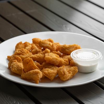 Deep Fried Fish Bites served on a plate with a dipping sauce on the side.