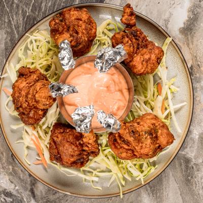 Chicken Lollipops served with a creamy sauce for dipping.