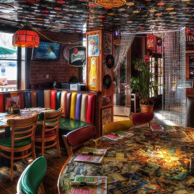 Retro-themed diner with colorful, striped seating, tables, and eclectic decor