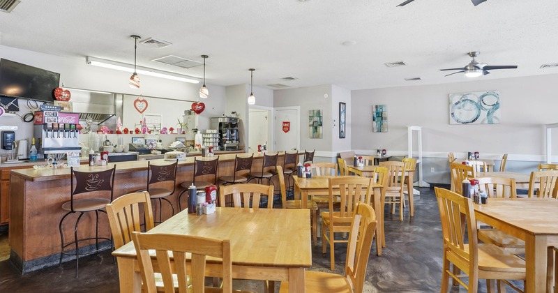 Interior, dining and bar area, tables for four, wooden top bar with stools