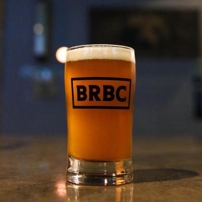 A glass of beer on a table.