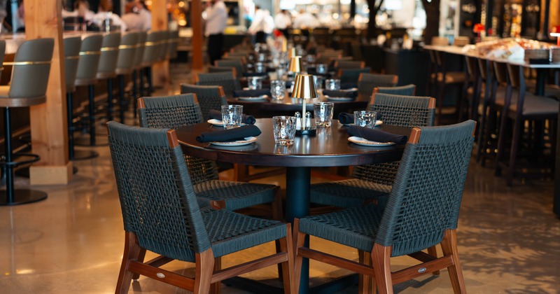 Modern restaurant interior with set tables and woven chairs