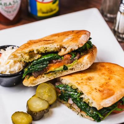 Tuna Panini served with pickles and coleslaw.