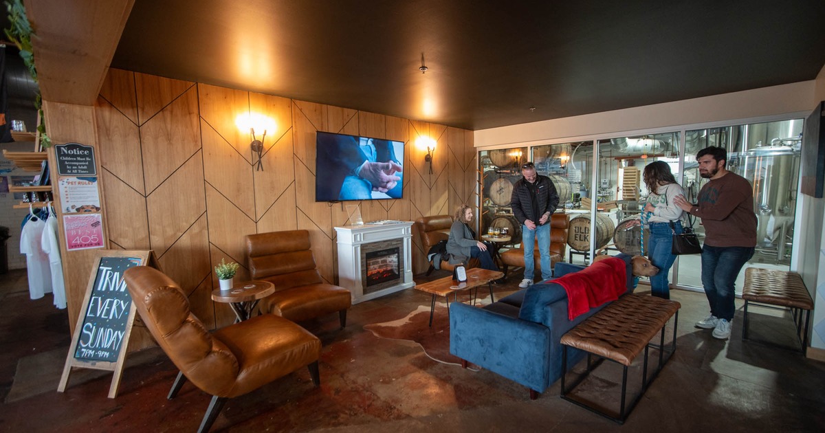 A small lounge area with armchairs and sofa, a fireplace and TV on a wall