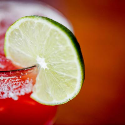 Pomegranate Margarita garnished with lime wheel, close up