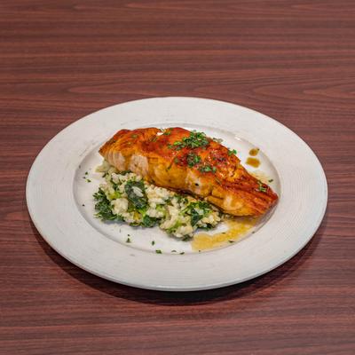 Grilled salmon, on a bed of rice and spinach.