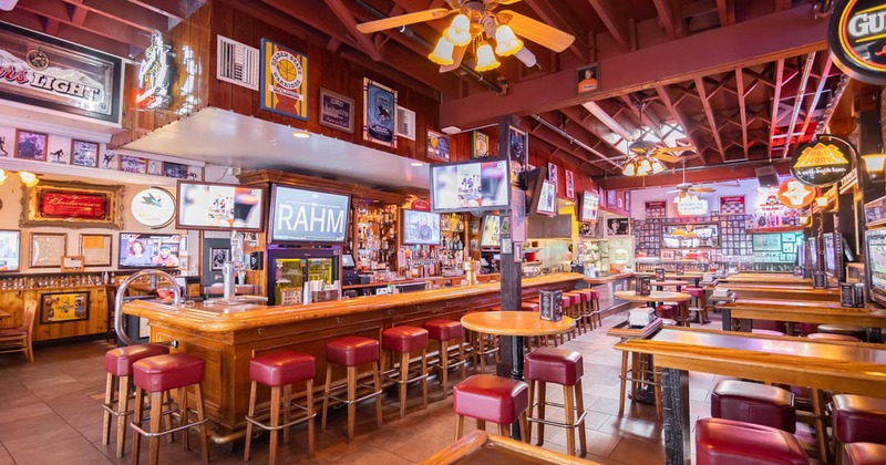 Interior seating area with a long counter and red stools
