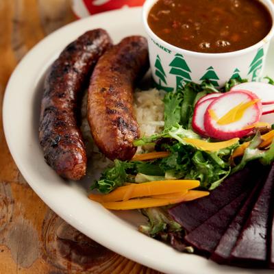 Grilled sausages served with salad and baked beans.