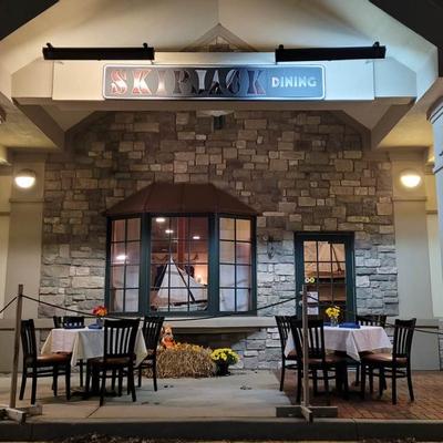 Outdoor area with a couple of tables in front of the entrance
