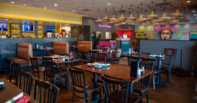 Interior, dining area, wooden top tables for four, seating booths in the back