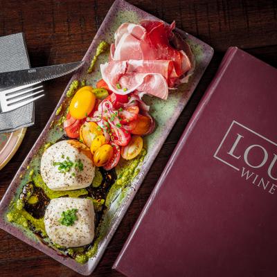 Grand board with meats cheeses olives and almonds.
