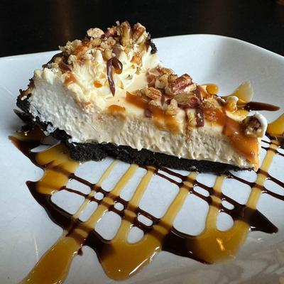 A slice of turtle pie drizzled with chocolate and caramel sauce.