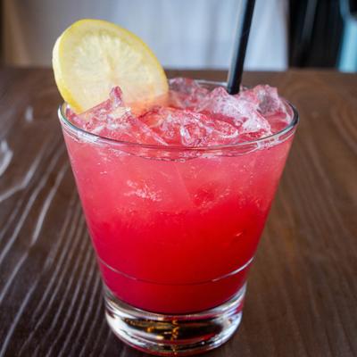 A glass of Vodka Hibiscus Refresher garnished with a lemon wheel.
