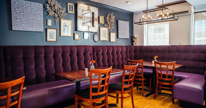 Interior, banquette seating and tables with chairs, wall decorated with lots of pictures