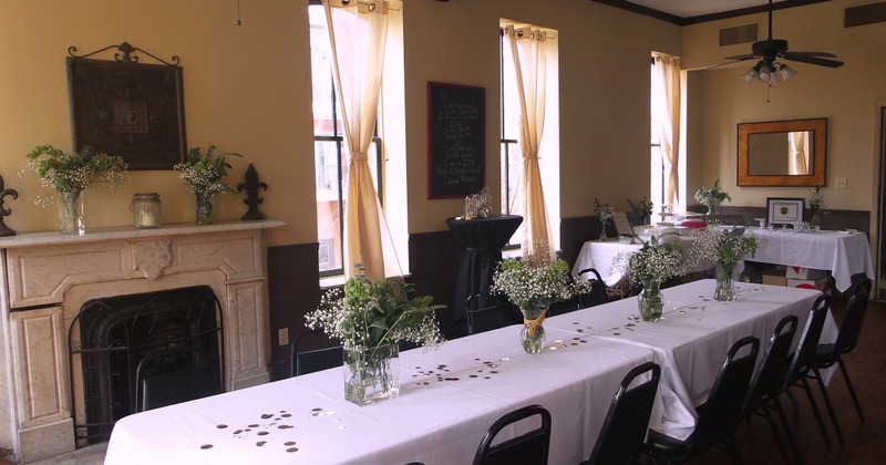 White tablecloths and flowers adorn a long table, creating an elegant setting