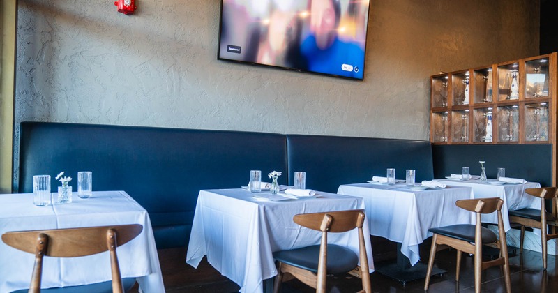 Interior, long banquette bench padded in marine blue leather, tables with chairs