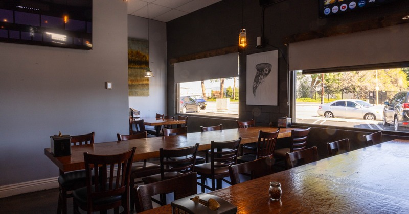 Interior, dining area, long wooden top table setups for ten, ready for guests